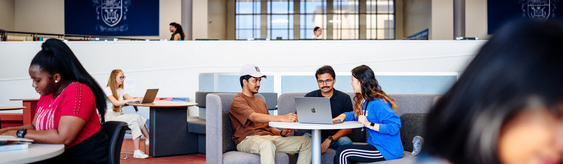 Students working on a laptop in the library